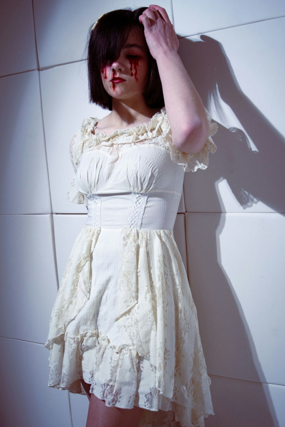 a woman in a white dress with blood on her face