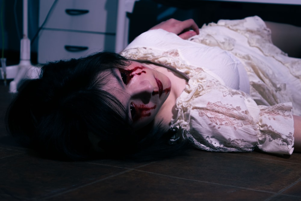 a woman laying on the floor in a white dress