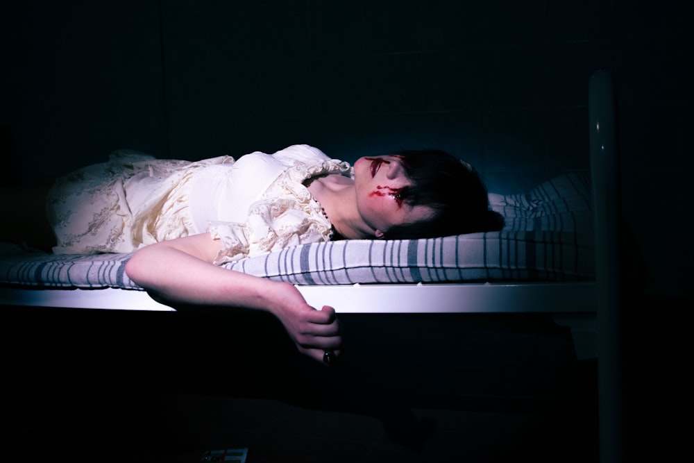 a woman laying on a bed in a dark room