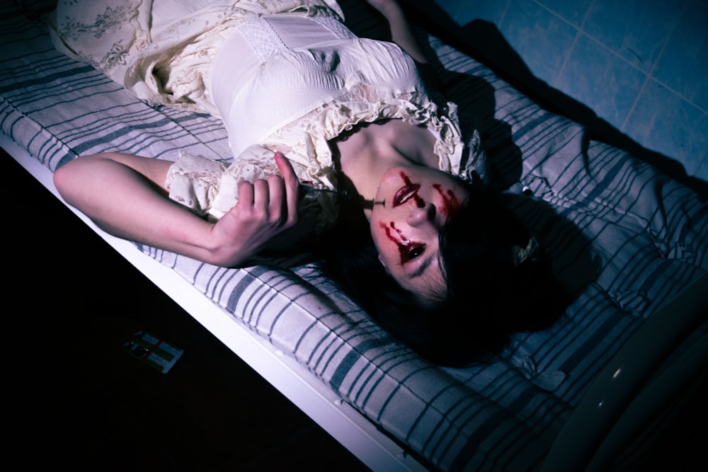 a woman laying on top of a bed in a dark room