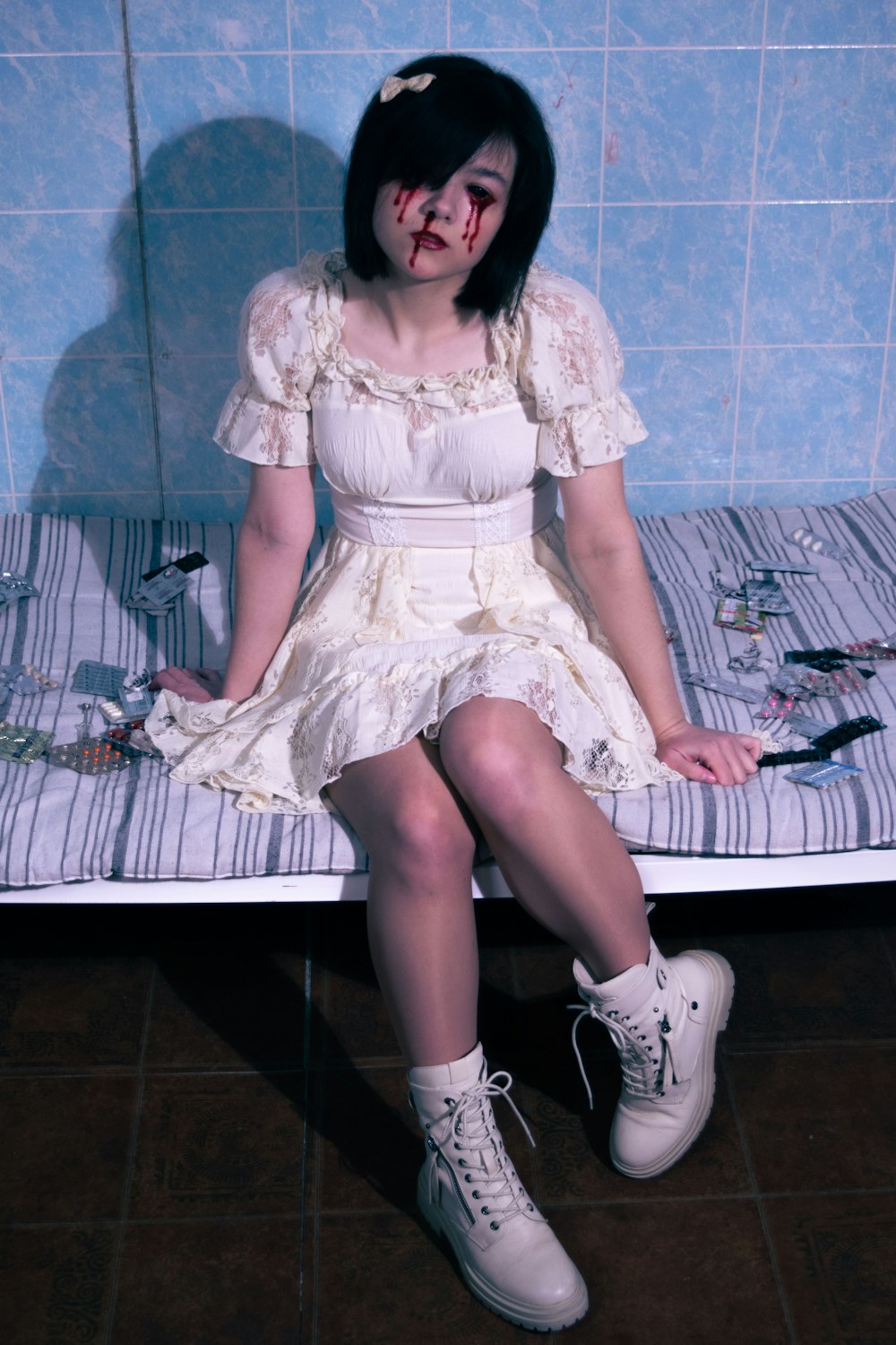 a woman sitting on a bed with a bloody face