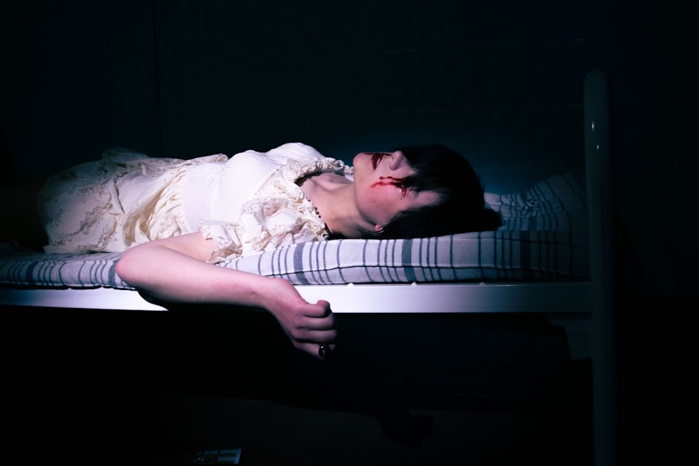 a woman laying on a bed in a dark room