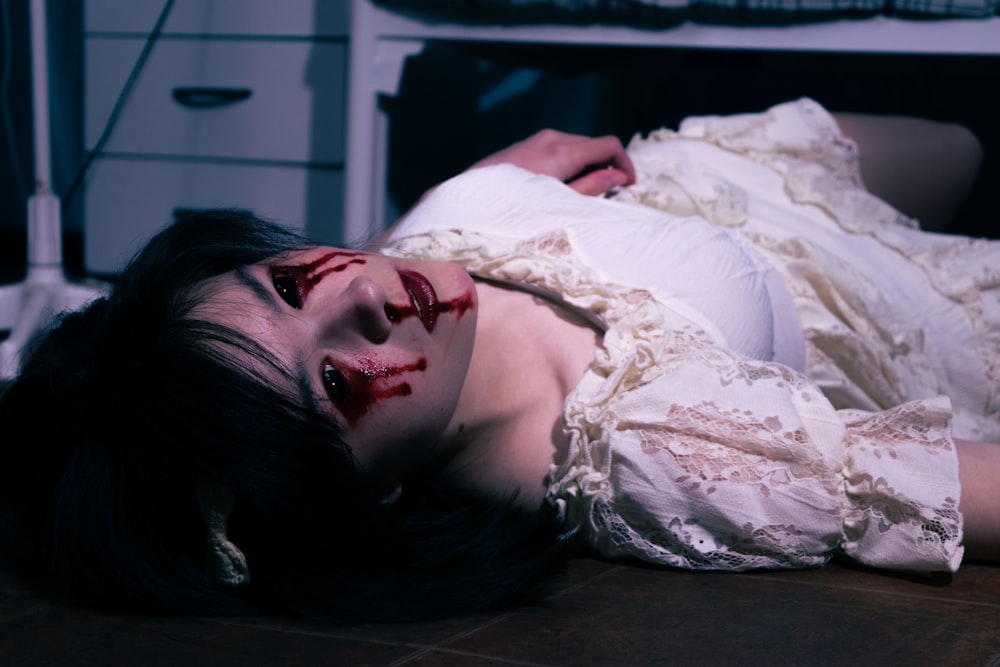 a woman with blood on her face laying on the floor