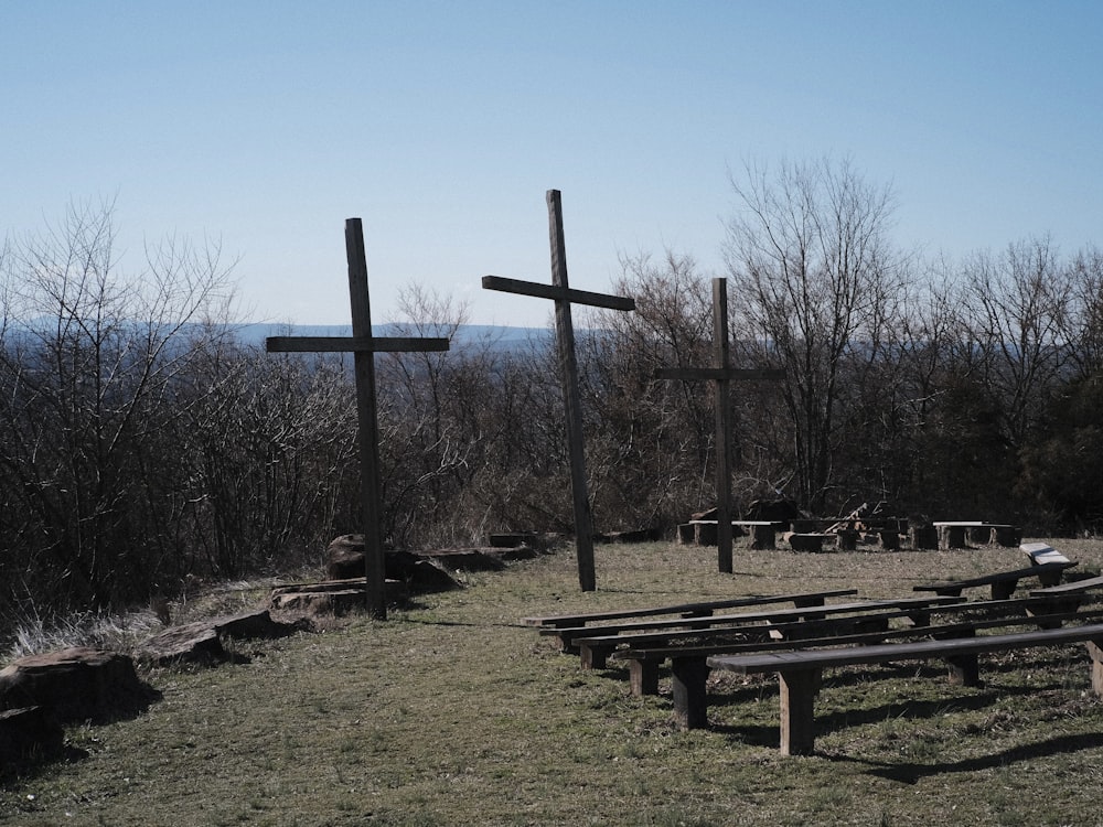 a couple of wooden crosses sitting on top of a grass covered field