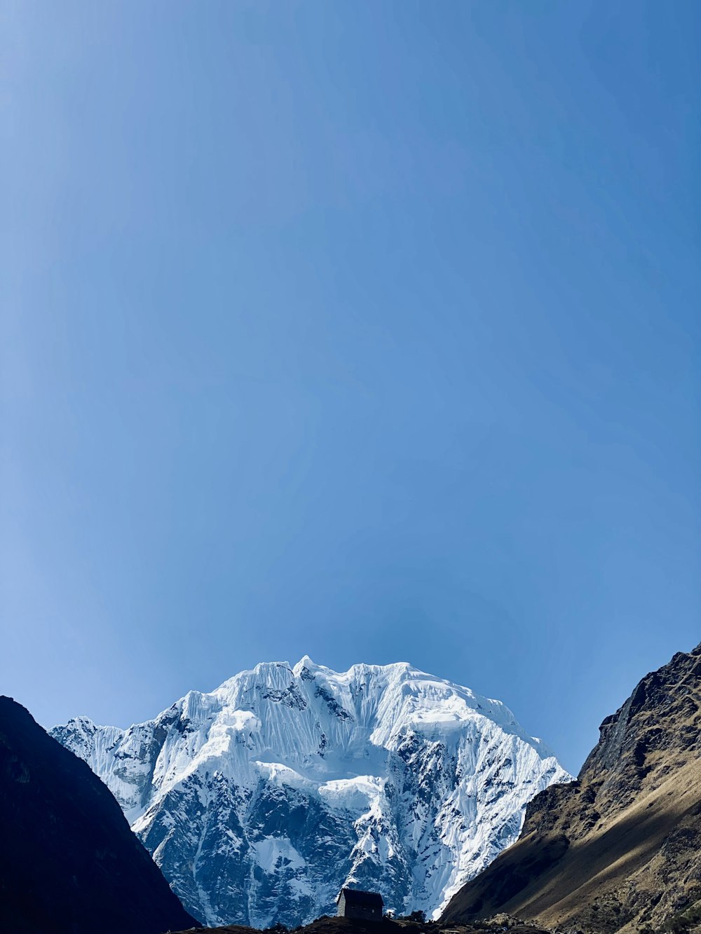 a view of a snow covered mountain from a valley