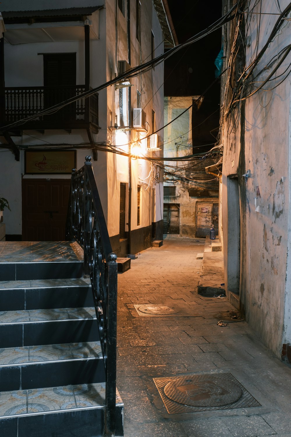 a dark alleyway with stairs leading up to a building