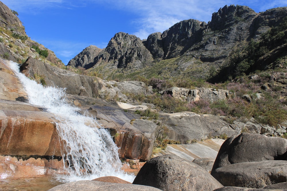 a small waterfall in the middle of a rocky area