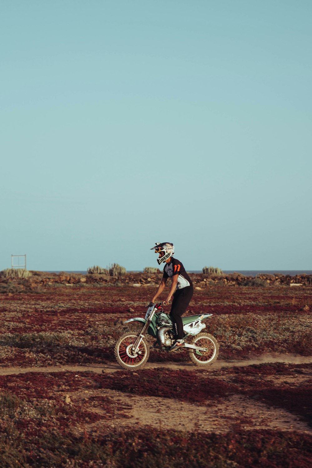 a man riding a dirt bike on a dirt road