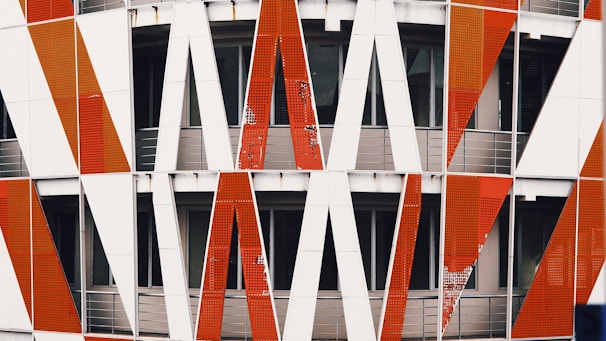 Exterior shot of a building featuring a complex pattern of red, white, and black paint finishes