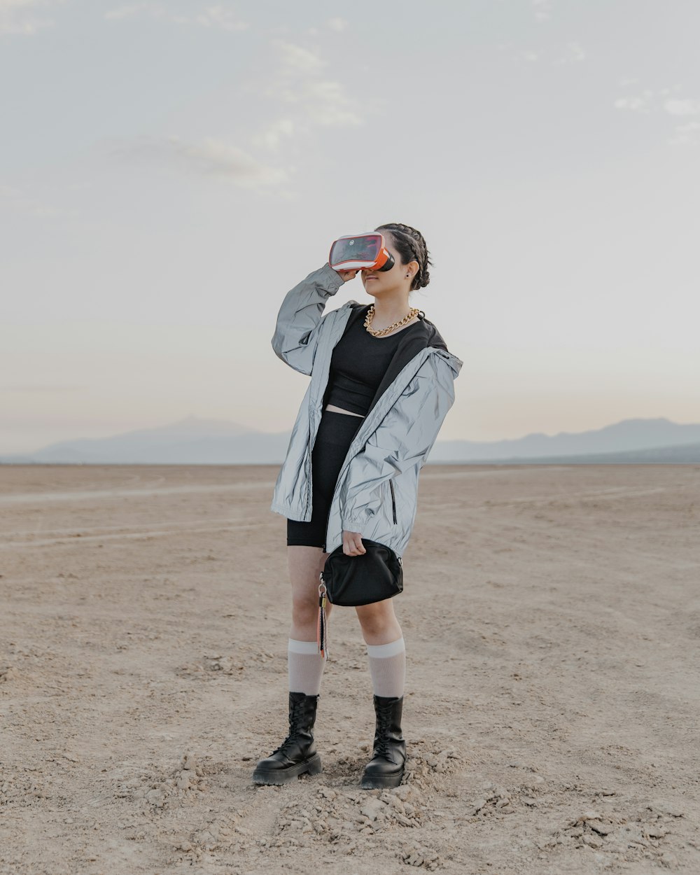 a woman standing in the middle of a desert