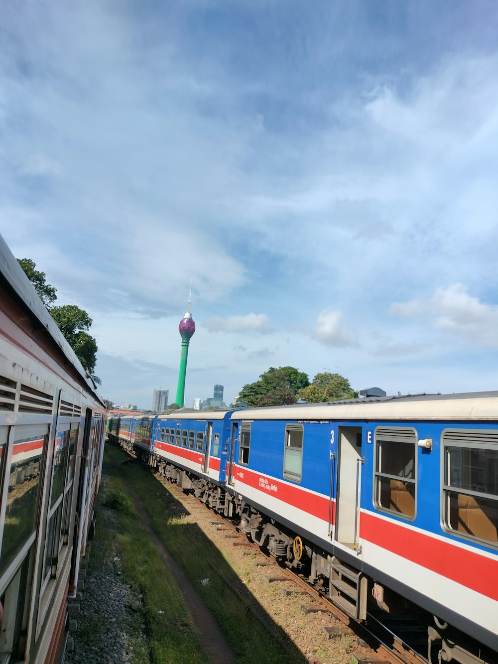 a blue and white train traveling down train tracks