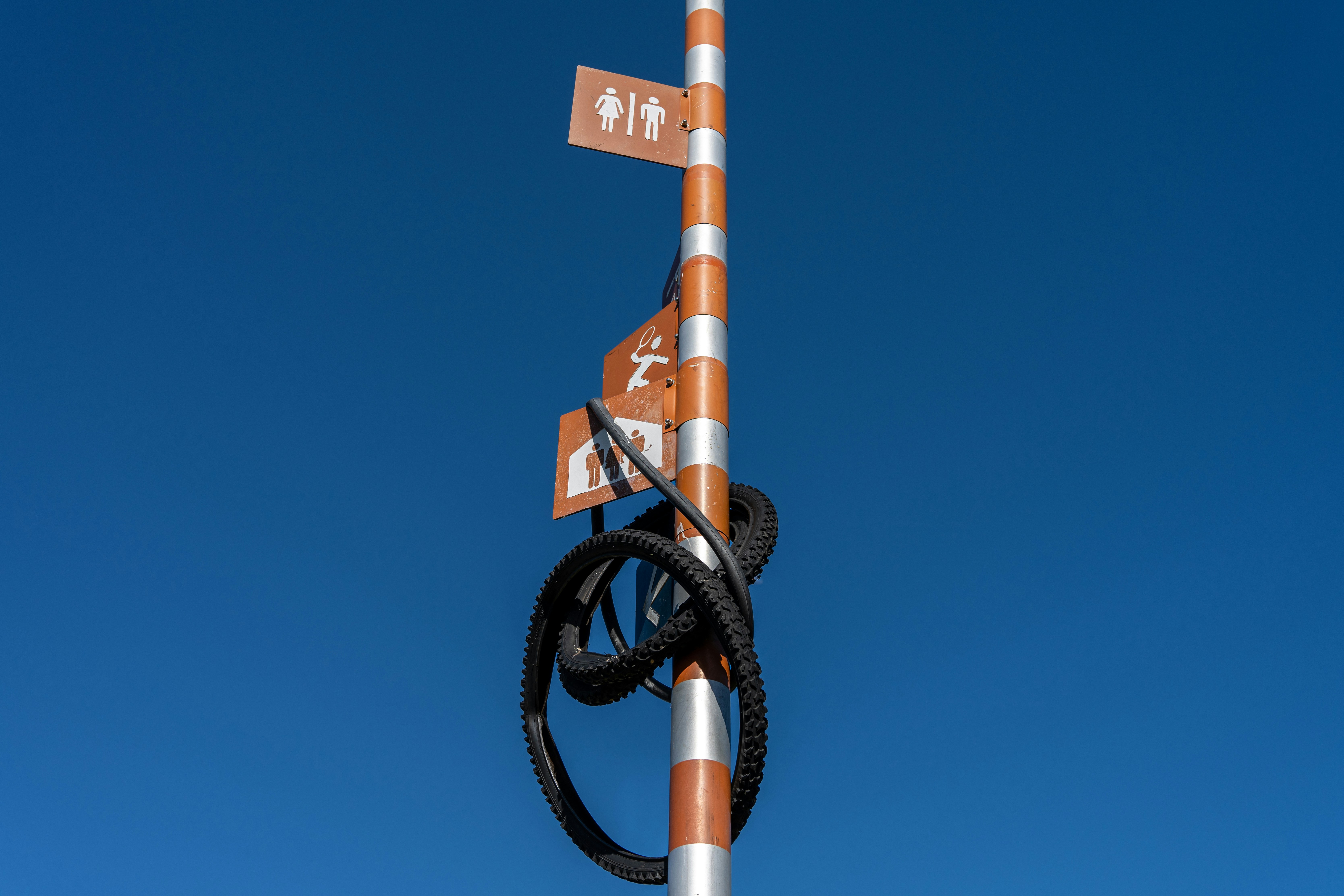 a street sign on a pole with a sky background