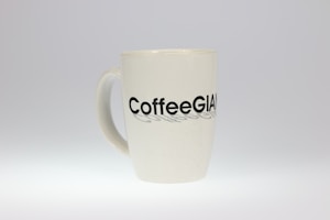 A white ceramic mug with the word 'CoffeeGiant' printed in bold black letters on its surface. The mug is simple and has a smooth, glossy finish.