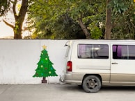 A delivery van from Viveros Araque parked outside a home with Christmas decorations visible through the window.