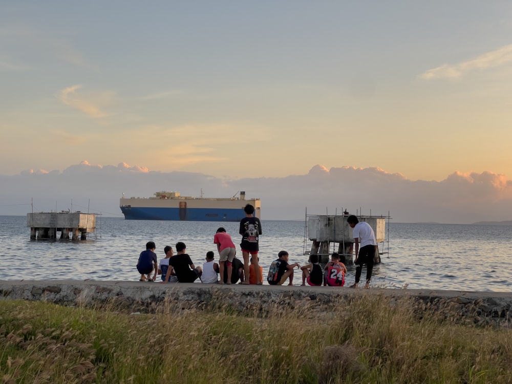 a group of people standing next to a body of water