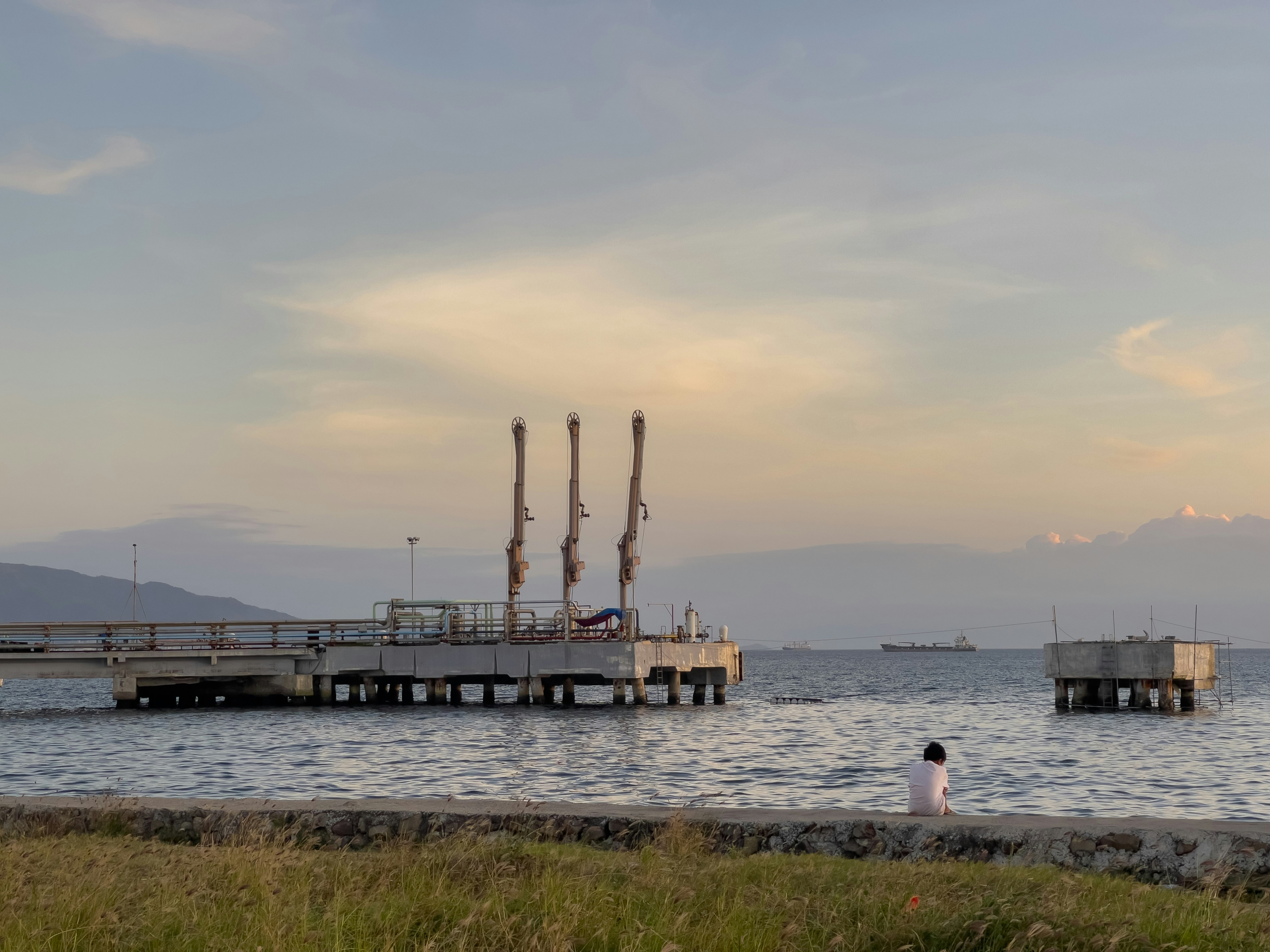 a person sitting on the shore of a body of water