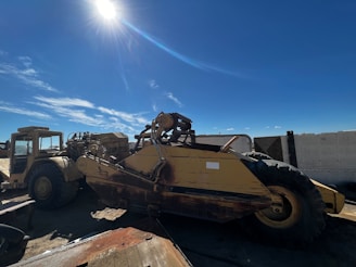 A skilled technician inspecting a heavy construction machine on a sunny worksite.