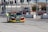 A brightly colored race car with the word 'Impala' on the front bumper is parked on a tarmac with a series of tall poles in the background. There are race track markings on the ground, and the surroundings include a fenced area decorated with red, white, and blue banners.