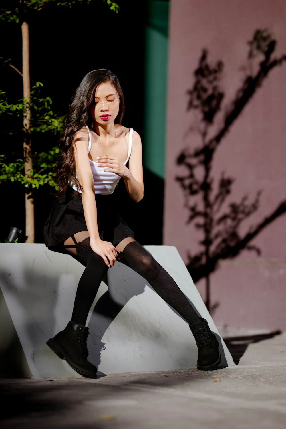 a woman sitting on top of a cement wall