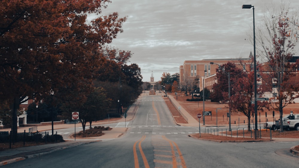 an empty street with a few cars parked on the side of the road