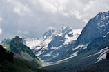 Snow-capped peaks of the Himalayas towering over a lush green valley.