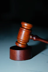Murdered by Darkness Image a wooden judge's hammer on top of a table