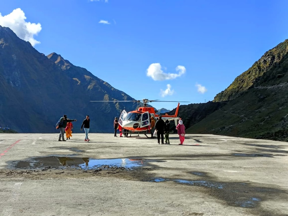 a group of people standing next to a helicopter