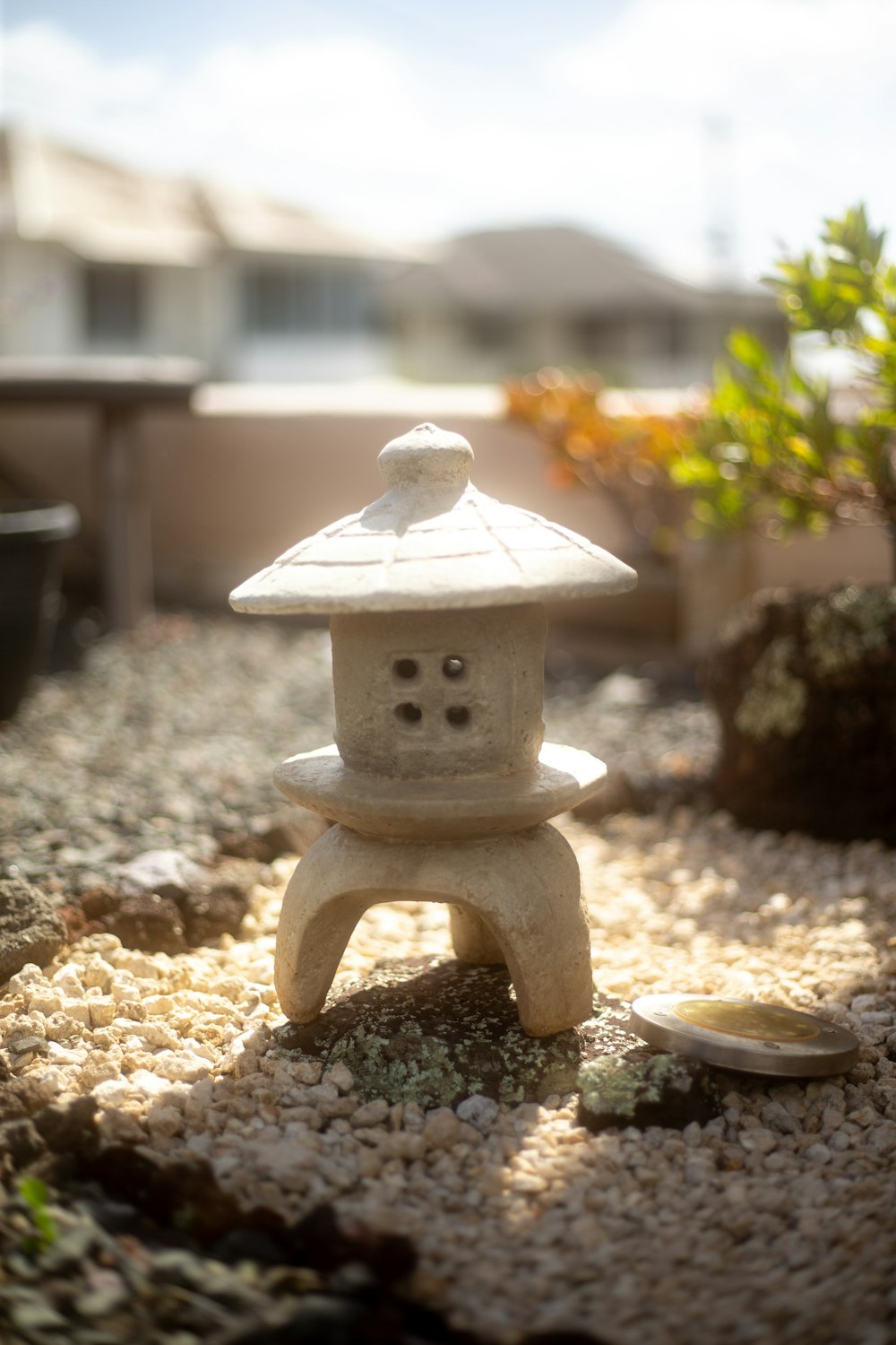 a small white bird house sitting on top of a gravel field