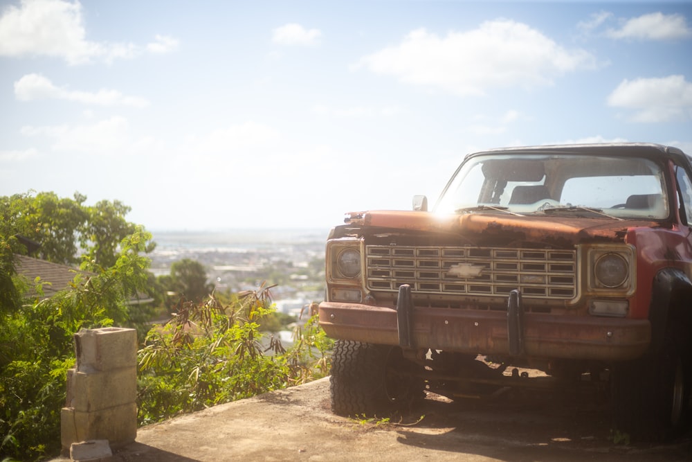 a red truck parked on top of a dirt road