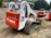 Multiple tracked skid steer loaders are parked on a dirt surface. The machinery, labeled with the brand name Bobcat and model T300, has a combination of white and bright red colors. The vehicles are surrounded by a natural setting, with trees in the background and construction materials nearby.