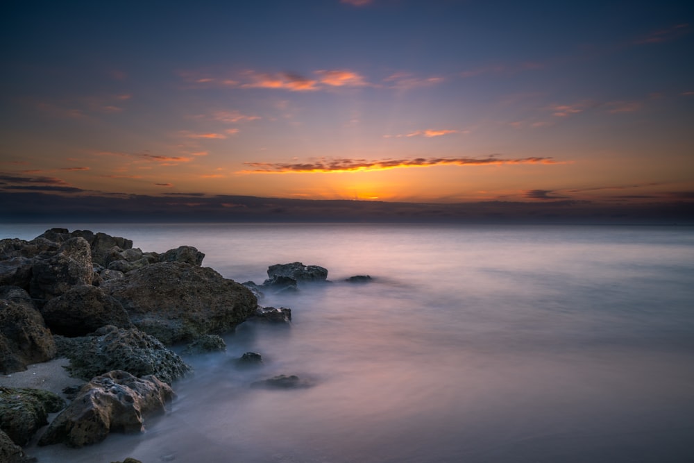 a long exposure photo of a sunset over the ocean