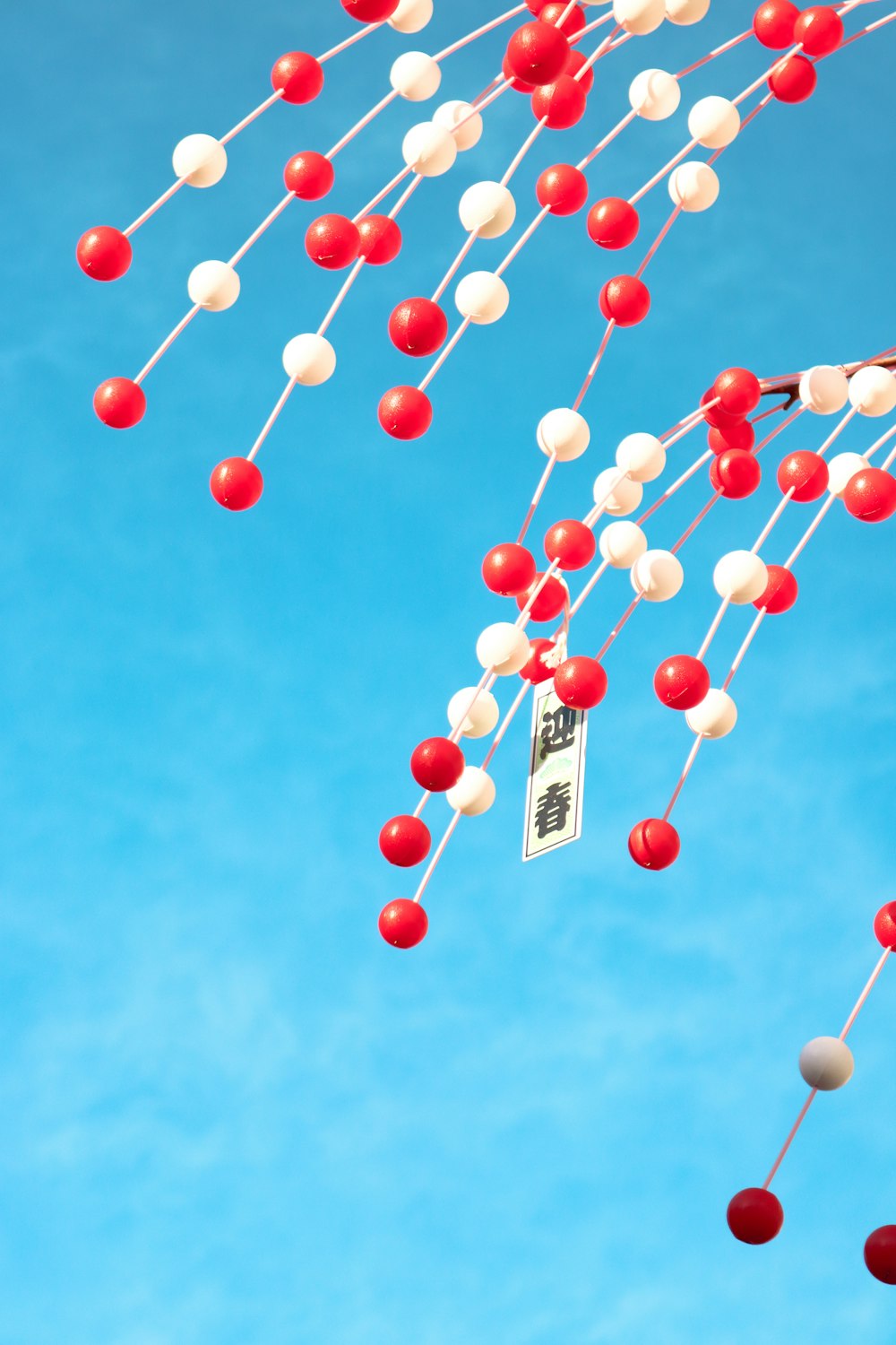 a bunch of red, white and blue balls hanging from a string