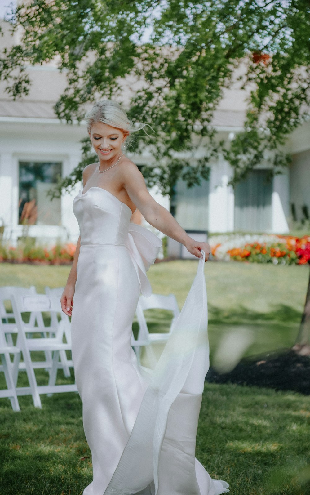 a woman in a white dress is standing in the grass