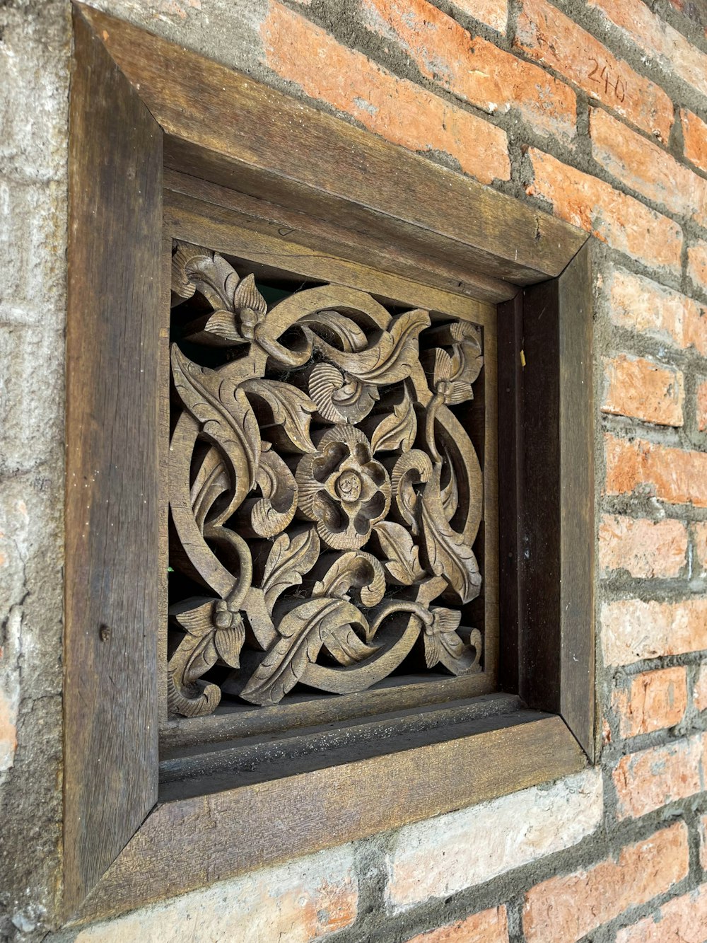 a decorative wooden window in a brick wall