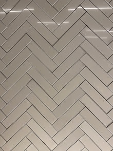 a bathroom with a white tiled wall and a toilet