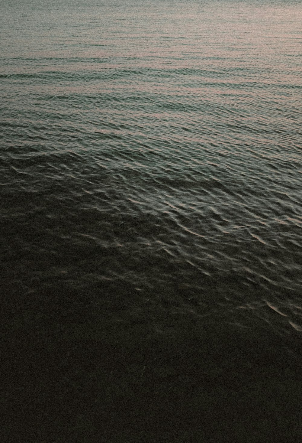 a large body of water sitting under a cloudy sky