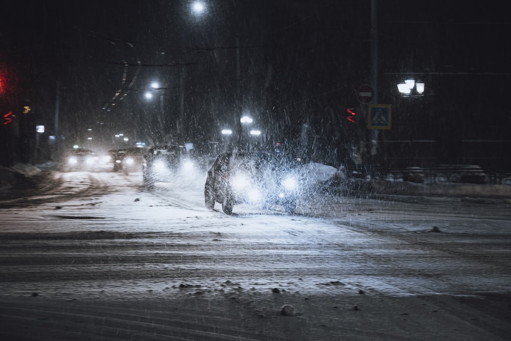 a person walking across a snow covered street at night