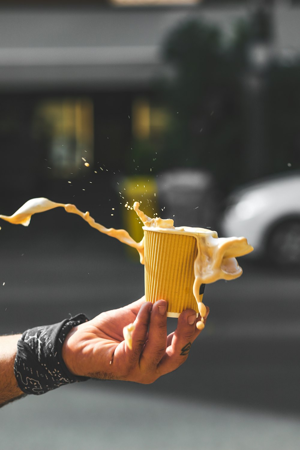 a hand holding a yellow cup of coffee