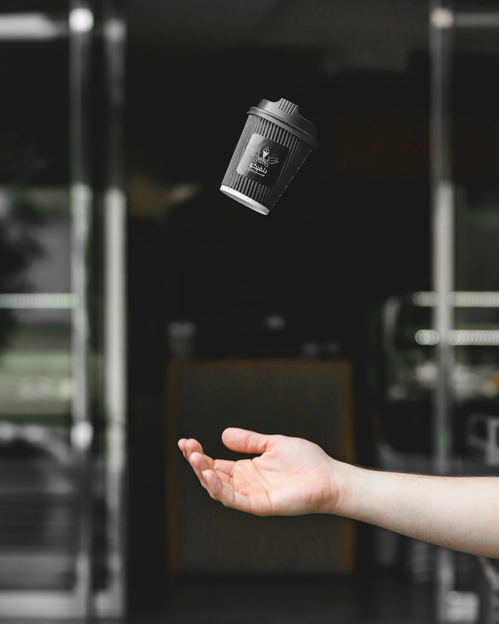 a person is throwing a coffee cup into the air