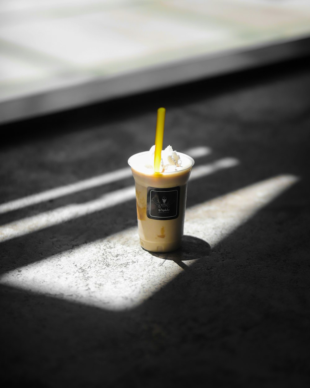 a cup of ice cream with a yellow straw