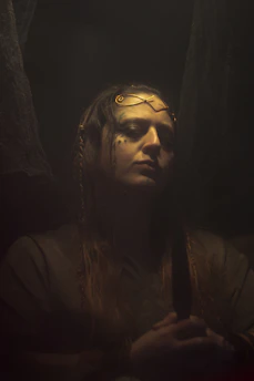 A moody gothic portrait of a fantasy rock girl surrounded by ethereal shadows and delicate miniatures.