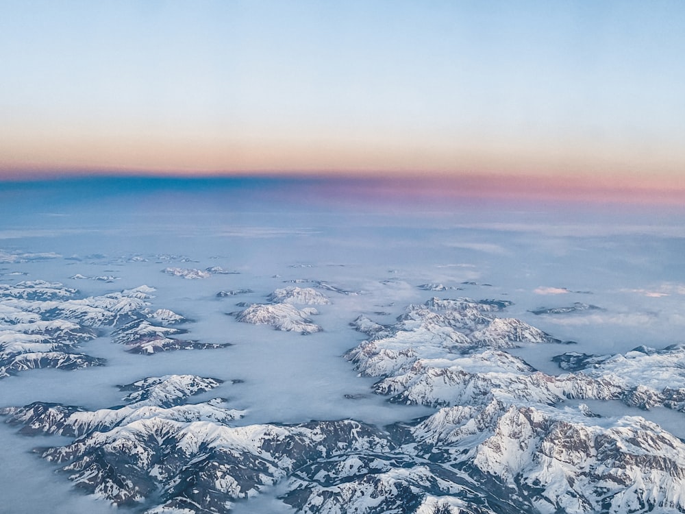 an aerial view of a mountain range covered in snow