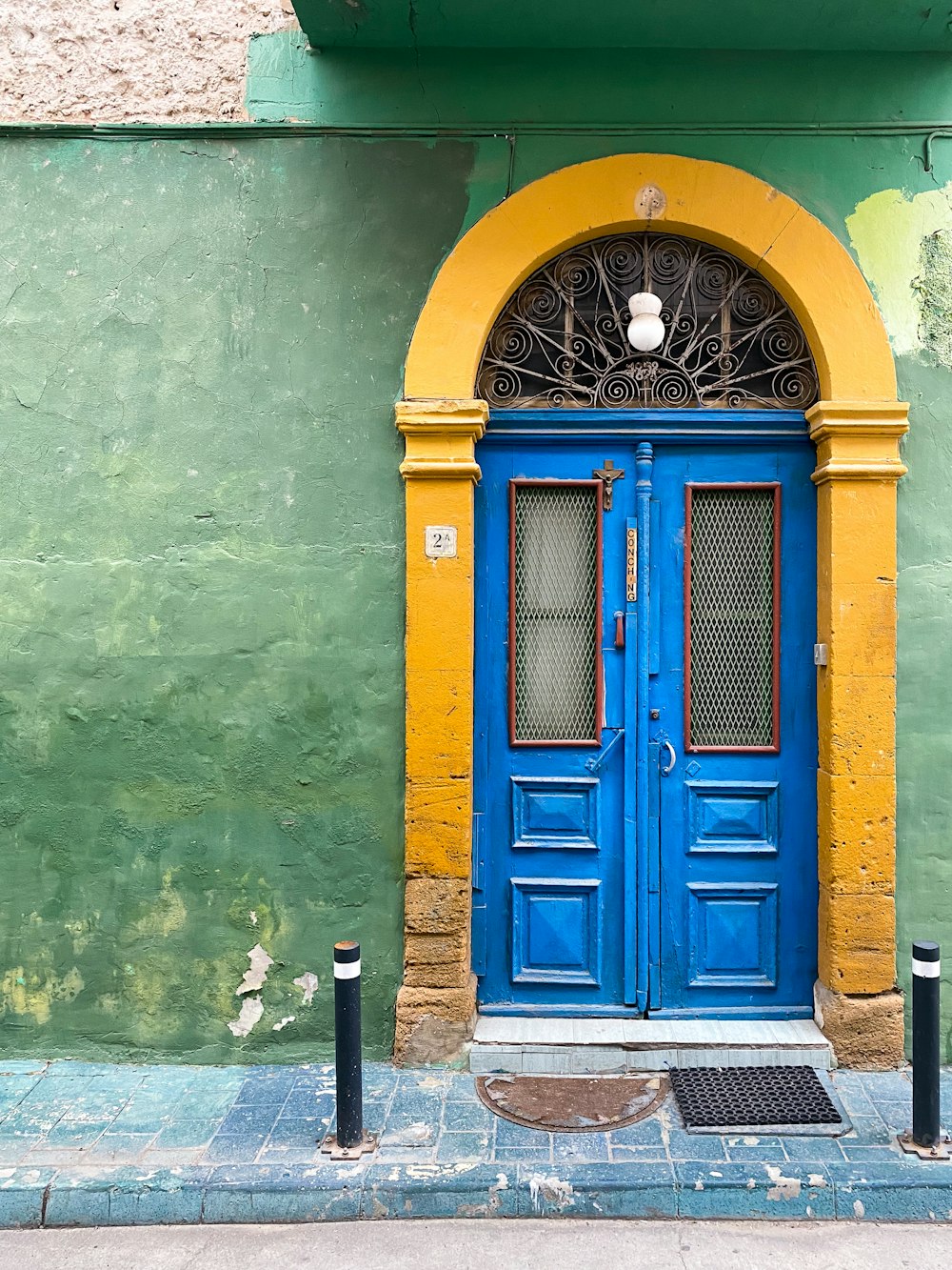 Eine blau-gelbe Tür an einem grünen Gebäude