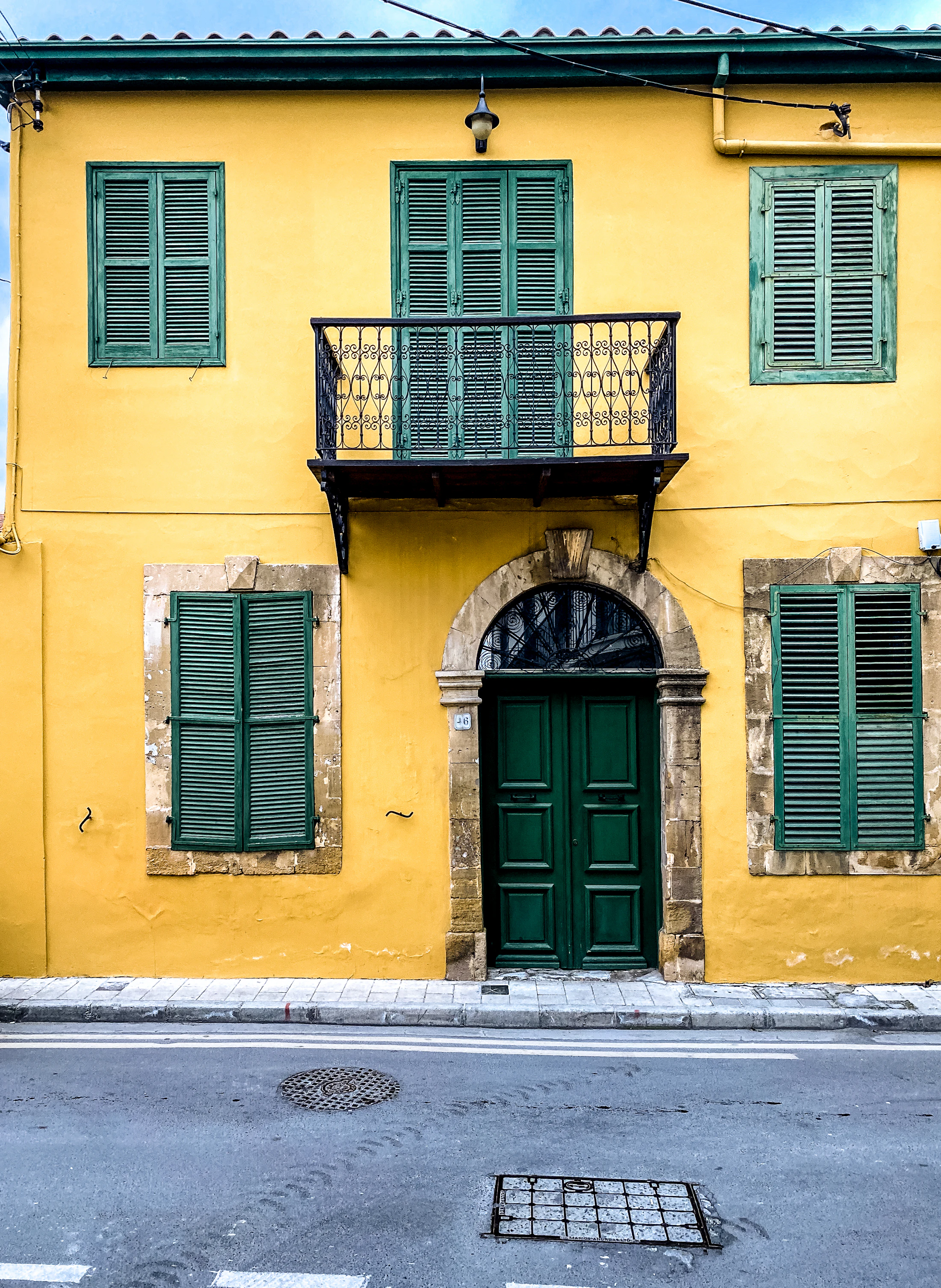 Yellow building with green shutters in Trypiotis, Nicosia, Cyprus