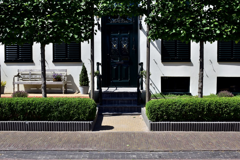 a bench sitting in front of a white building