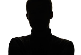 a silhouette of a man with his arms crossed