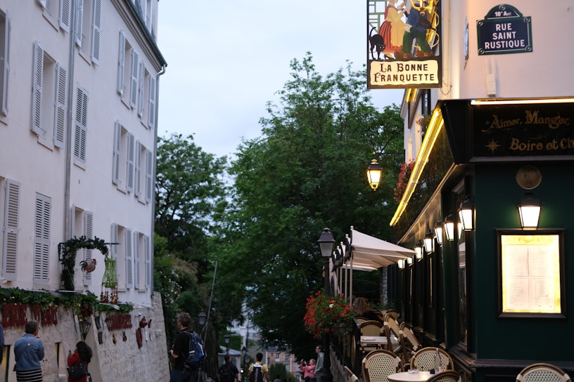 A vibrant street scene in Paris with outdoor café seating and blooming flower boxes.