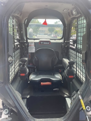 Operator cabin of a tracked loader with controls visible.