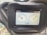 A digital screen displaying vehicle dashboard indicators. It shows two circular gauges; the left one depicts an engine temperature gauge with a water symbol, and the right one indicates a fuel gauge. The top left corner displays the hours used, reading 298.5 hrs, and the bottom shows a digital number 1720 with a lighting symbol beside it. The screen is surrounded by a black frame held in place by a bolt.
