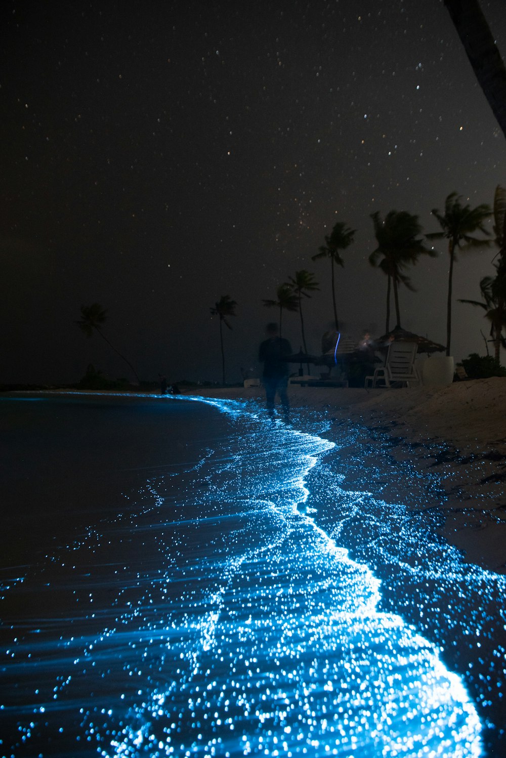 a man walking on a beach at night